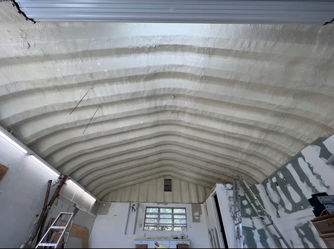 Spray polyurethane foam applied to the underside of a metal roof deck in Newman